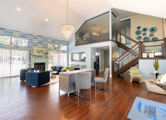 a living room with a staircase and a dining room with chairs and a couch  at Fisherman's Landing Apartment Homes, Tampa, Florida
