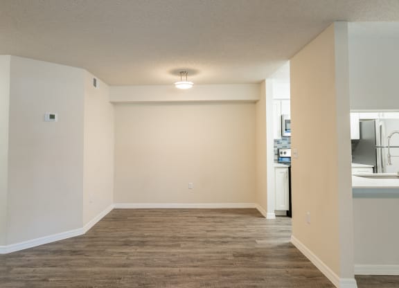 an empty living room and kitchen with a wood floor and white walls  at Fisherman's Landing Apartment Homes, Florida