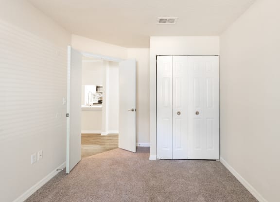 a bedroom with a closet and a door to a bathroom  at Fisherman's Landing Apartment Homes, Florida