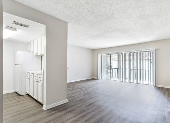 an empty living room and kitchen with a large window at Greenwich Commons Apartment Homes, Tampa, 33613
