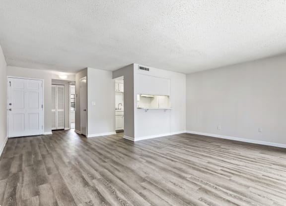an empty living room with white walls and wood flooring at Greenwich Commons Apartment Homes, Florida