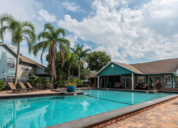 a large swimming pool with a house in the background at Madison Oaks Apartment Homes, LLC, Palm Harbor, FL 34684