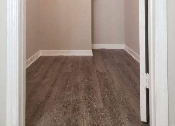 a spacious closet with shelves and a wood floor in an empty room at Madison Oaks Apartment Homes, LLC, Florida