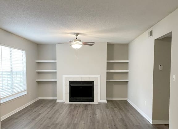 an empty living room with a fireplace and shelves at Madison Oaks Apartment Homes, LLC, Florida