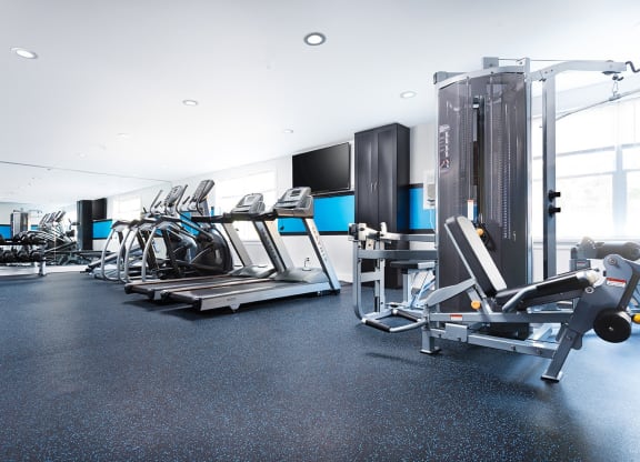a large fitness gym with cardio equipment and a large window at Aspen Grove Apartment Homes, Warminster, PA