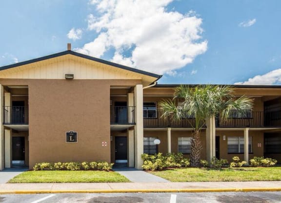 a building with palm trees in front of it at Oak Manor Apartment Homes, Tampa