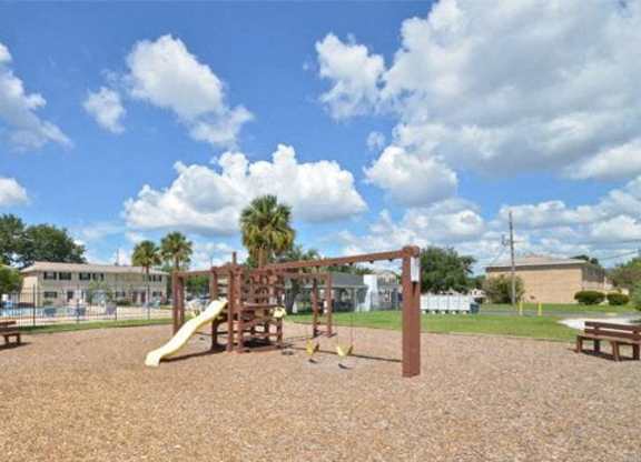 A playground with a slide and a swing set.