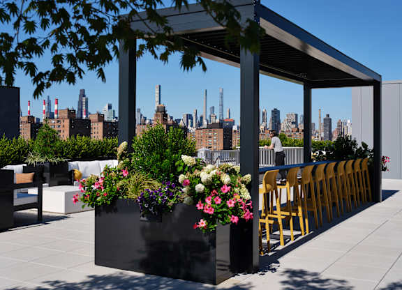 A patio with a table and chairs overlooking a city skyline.
