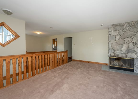 a large living room with a stone fireplace