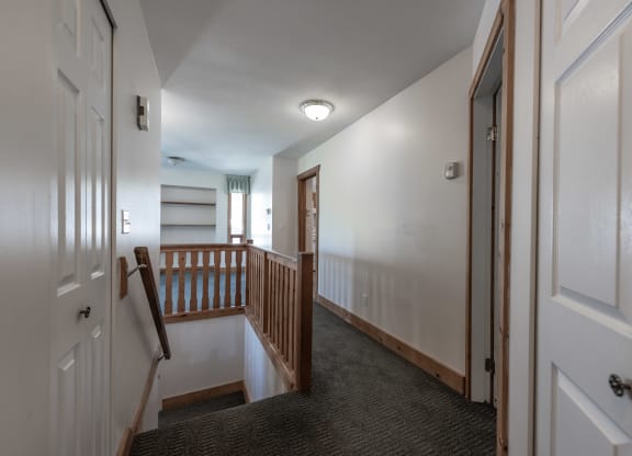 a view of the hallway from the top of the stairs