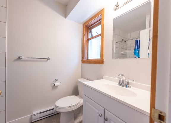 a bathroom with a toilet sink and mirror