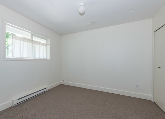 a bedroom with white walls and carpet