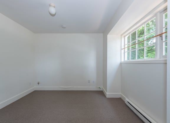 a small bedroom with a large window and white walls
