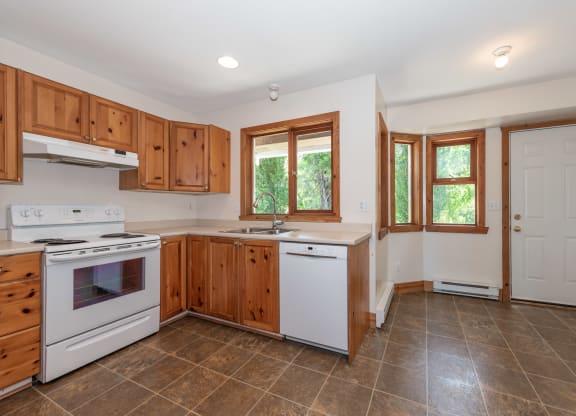 a kitchen with white appliances and wooden cabinets