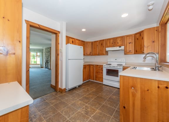 a kitchen with white appliances and wooden cabinets