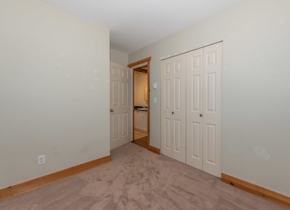 a bedroom with two closets and a door to a bathroom