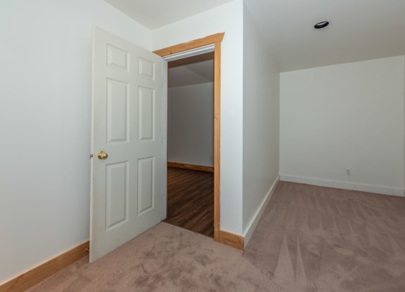 a bedroom with an open door and a carpeted floor