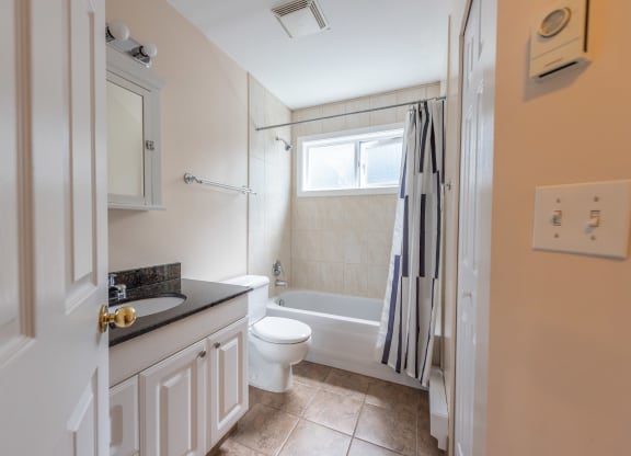 a bathroom with a white toilet next to a white bath tub