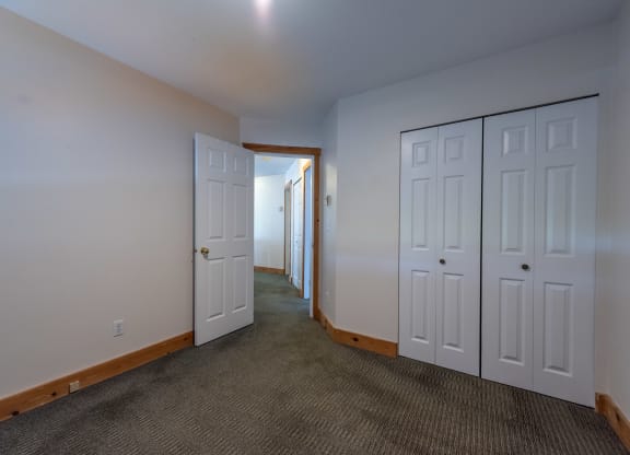 a bedroom with two doors and a carpeted floor