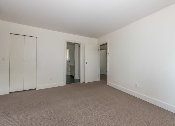 a bedroom with white walls and carpet