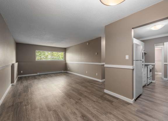 A spacious living room with a kitchen in the background.