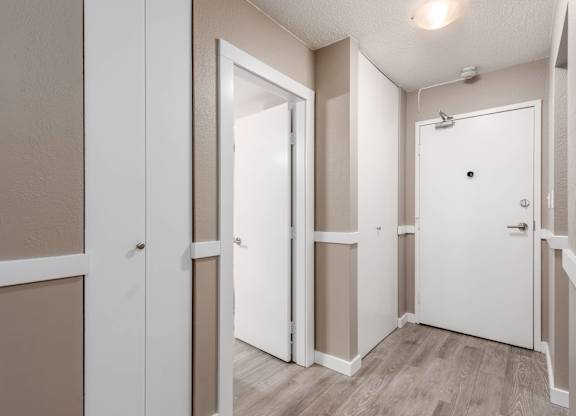 A white door is open in a room with beige walls.