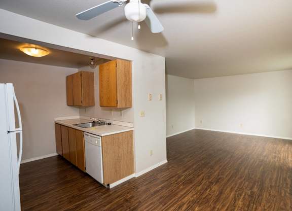 A kitchen with a white fridge and wooden cabinets.