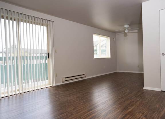 A room with wooden floors and a ceiling fan.