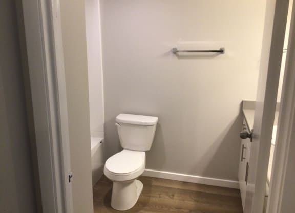 a white toilet sitting in a bathroom next to a towel rack