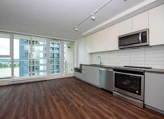 a kitchen with white cabinets and stainless steel appliances
