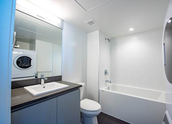 a bathroom with a toilet sink mirror and bathtub