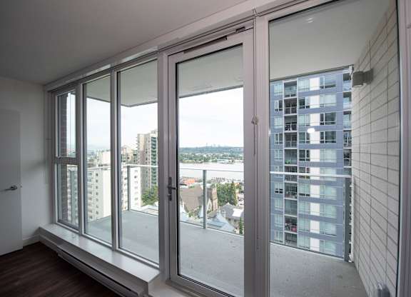 a bedroom with a large window and a balcony