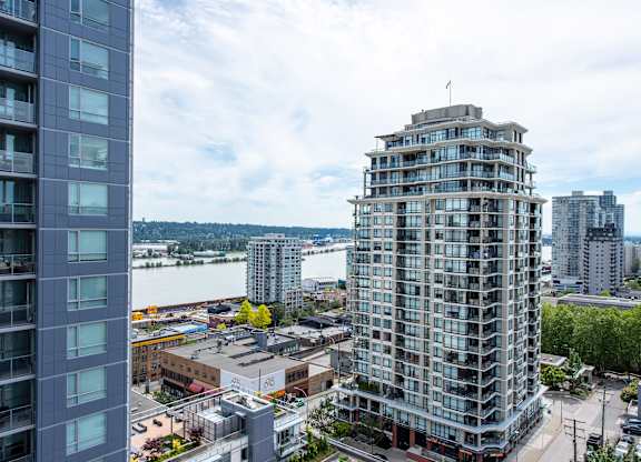an aerial view of a tall building in a city with a river in the background