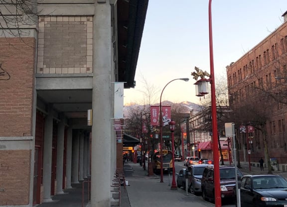 a city street with cars parked on the side of the road and a building on the right