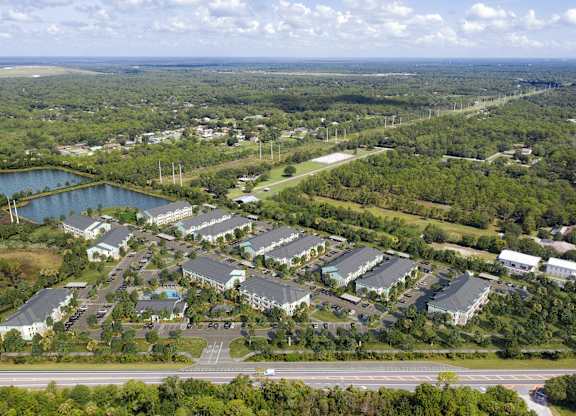 A bird's eye view of a resort with a large lake and a road. at Allegra at Cocoa in Cocoa, FL, 32926