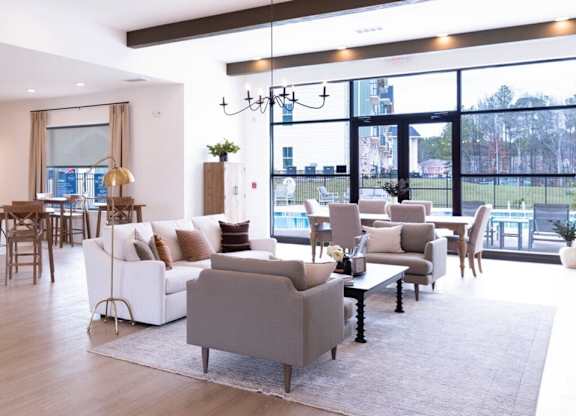 A modern living room with a kitchen area in the background.