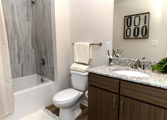 A bathroom with a toilet, sink, and shower.