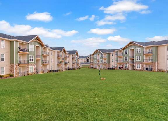 Apartment complex with a green lawn in front.