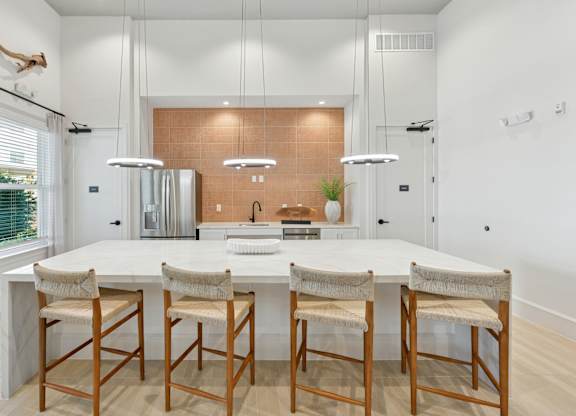 A modern kitchen with a white table and chairs.at Allegra at Cocoa in Cocoa, FL, 32926