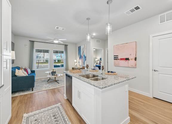 A kitchen with a blue couch and a painting on the wall.at Allegra at Cocoa in Cocoa, FL, 32926