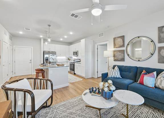 A modern living room with a blue couch and a coffee table.at Allegra at Cocoa in Cocoa, FL, 32926