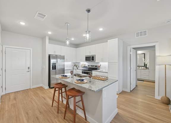 A kitchen with a white countertop and wooden floors.at Allegra at Cocoa in Cocoa, FL, 32926