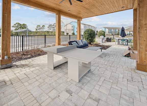 A white table with a black cushion is in the middle of a patio. at Allegra at Cocoa in Cocoa, FL, 32926