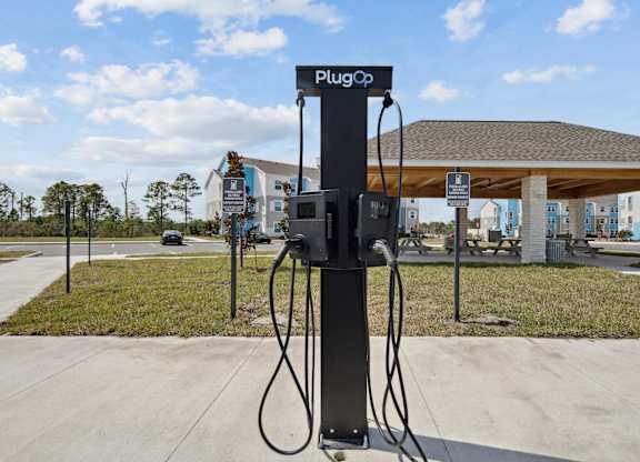 A PlugCo charging station sits on a sidewalk. at Allegra at Cocoa in Cocoa, FL, 32926
