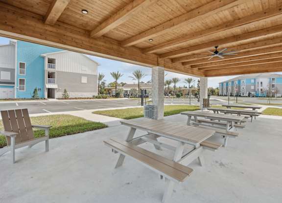 A wooden picnic table is in the middle of a concrete patio. at Allegra at Cocoa in Cocoa, FL, 32926