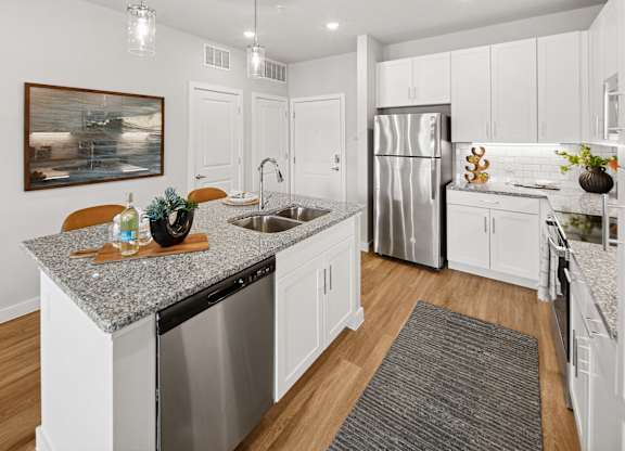 A kitchen with a granite countertop and stainless steel appliances. at Allegra at Cocoa in Cocoa, FL, 32926