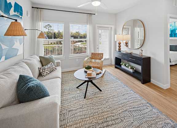 A living room with a white couch and a grey rug. at Allegra at Cocoa in Cocoa, FL, 32926