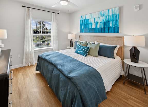 A bedroom with a large bed and a window with curtains. at Allegra at Cocoa in Cocoa, FL, 32926