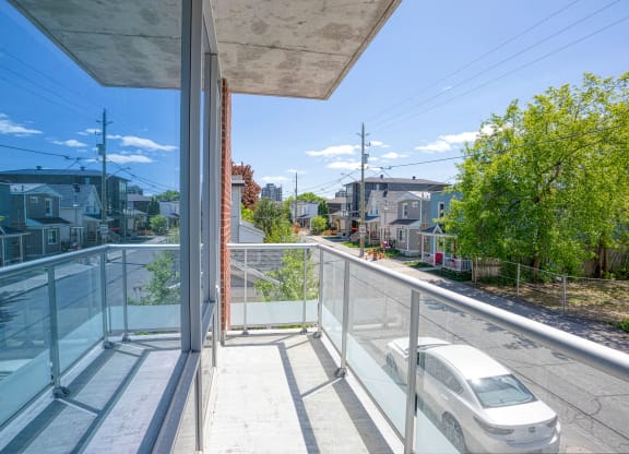 a balcony with glass railing and a white car on it