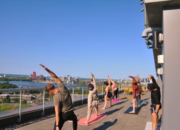 a group of people doing yoga on the roof of a building